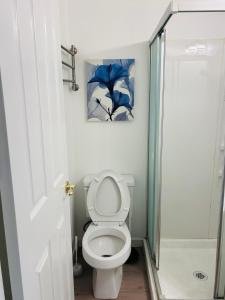 Un baño con inodoro y un cuadro en la pared. en #Marbella Lane - Lit & Laid Back Eastvale Home, en Corona
