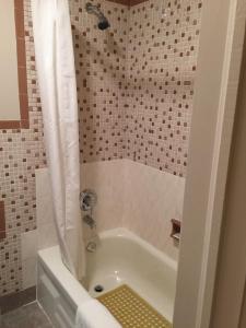 uma casa de banho com uma banheira branca e um chuveiro em Hotel Motel Arnold em Woburn