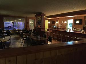 a restaurant with tables and chairs and a bar at Hotel Motel Arnold in Woburn