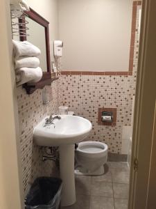 La salle de bains est pourvue d'un lavabo et de toilettes. dans l'établissement Hotel Motel Arnold, à Woburn