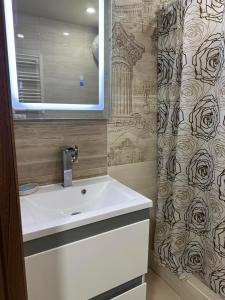 a bathroom with a sink and a shower curtain at Театральна Дванадцять in Pervomaysʼk +7 photos