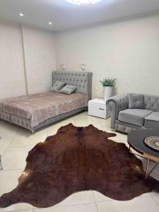 a bedroom with a bed and a couch and a rug at Театральна Дванадцять in Pervomaysʼk