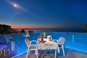 a table and chairs on a balcony at night at Hotel Villa Ombrosa in Portoferraio