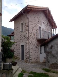 a stone house with a balcony on the side of it at Casa Clelia in Colico
