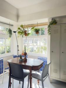 Un comedor con mesa y sillas y ventanas. en Apartment in former Bathhouse, en Ámsterdam
