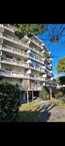 a tall apartment building with a tree in front of it at VARIE STRUTTURE Queste strutture NON FORNISCE lenzuola da letto e asciugamani in Lido Adriano