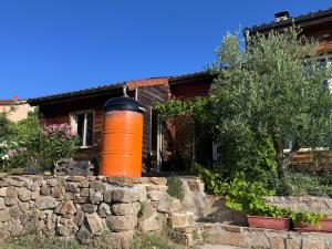 una casa con un barile arancione in cima a un muro di pietra di Le Montagnon a Lupé