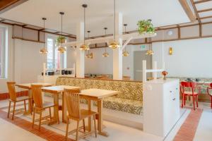 a restaurant with tables and chairs and a bench at Le Petit Hôtel in Saint-Jean-de-Luz