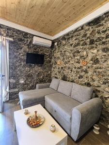 ケパロにあるKallisto Luxury Apartmentsの石壁のリビングルーム(ソファ付)
