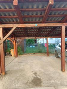 a garage with a wooden roof with a car parked under it at Lovely 1- bedroom apartment in Skofja Loka in Škofja Loka