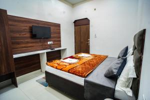 a bedroom with a bed with a television on it at Shri Bankey Bihari Guest House in Mathura +22 photos