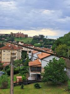 a view of a town with a castle in the background at Apartamento MILA centro in Comillas