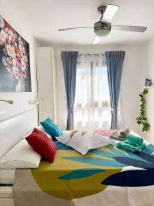 a bedroom with a bed with colorful pillows on it at El beso del mar in Costa de Antigua