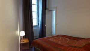 a bedroom with a bed and a window and a door at Les Boiseries in Dole