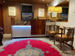 a waiting room with a red rug and chairs and a counter at FlexiStay Hotel in Cape Town