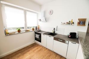 a kitchen with white cabinets and a window at Wies'n Ruhe DTV 4-Sterne in Oberviechtach +11 photos