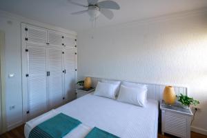 a bedroom with a white bed and a ceiling fan at Mesude Hanim " Billur Pinar" in Datca