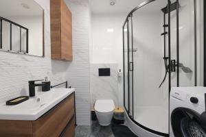 een badkamer met een wastafel, een toilet en een douche bij Bałtyckie Tarasy by Q4Apartments in Władysławowo +8 foto's