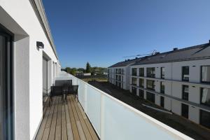 een balkon van een gebouw met twee stoelen erop bij Bałtyckie Tarasy by Q4Apartments in Władysławowo
