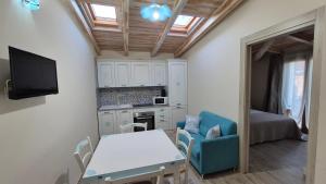a living room with a table and a kitchen at Su Chélu in Villasimius