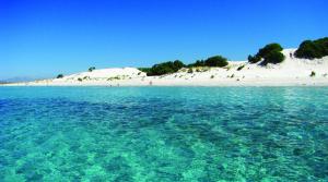 a view of a beach with sand dunes and water at Sa Domu Sarda casa vacanza in Piscinas