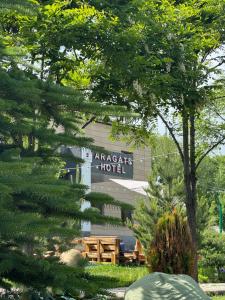 AragatsAragats Hotel的树后有一家美国酒店的标志