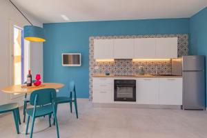 a kitchen with blue walls and a table and chairs at Bel Horizonte 6 in Capoliveri +77 photos