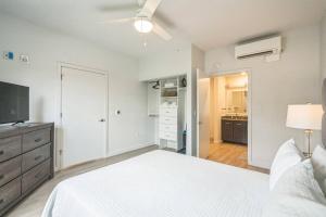a bedroom with a white bed and a television at Luxe 1B|Pool|Marble Falls Escape in Marble Falls +20 photos