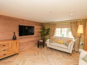 a living room with a couch and a flat screen tv at Clematis Cottage in Whitby