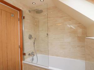 a bathroom with a shower with a tub at Clematis Cottage in Whitby +27 photos
