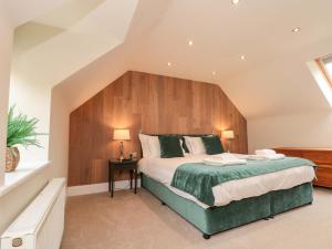 a bedroom with a large bed with a wooden headboard at Clematis Cottage in Whitby