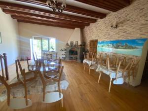 a dining room with chairs and a table and a fireplace at Хуторок у Зіни in Sanzhiyka