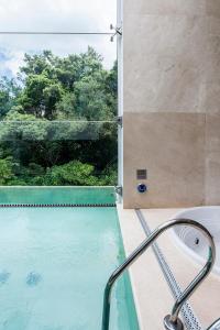 a bathroom with a swimming pool and a window at Motel Acqua (Adult Only) in Curitiba