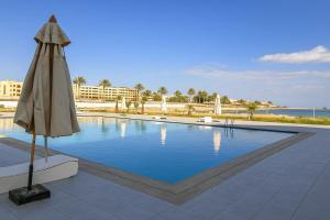 a large swimming pool with an umbrella and an umbrella at Scandic Resort in Hurghada, EGYPT in Hurghada