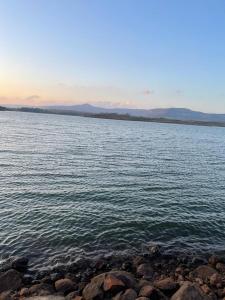 a large body of water with rocks on the shore at Bellajooz Lake Resort in Takwa Budrukh
