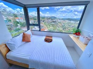 a bed in a room with a large window at Villa Đà Lạt Trung Nghĩa in Ấp Ða Lợi