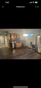 cocina con suelo de madera y electrodomésticos de acero inoxidable en Rooms for Hosting, en Calgary