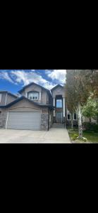 dos fotos de una casa con garaje en Rooms for Hosting, en Calgary