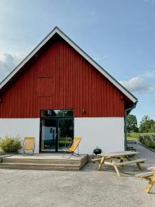 a red barn with two chairs and a picnic table at Modern Guesthouse Near Åsnen National Park in Jät +11 photos