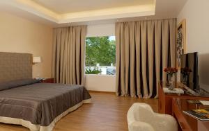 a bedroom with a bed and a desk and a television at Theoxenia Residence in Athens +47 photos