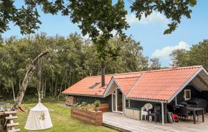 a small house with an orange roof and a deck at Three-Bedroom Holiday Home In Thyholm in Thyholm