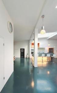 a white living room with a clock on a wall at Stylisches City Loft mit Terrasse, zentral & eventgeeignet in Mannheim