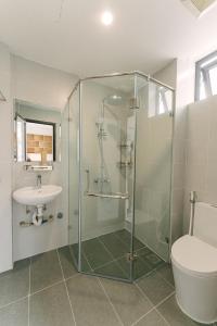 a bathroom with a shower and a toilet and a sink at Boho Apartment 81 - Ton That Thiep in Hanoi