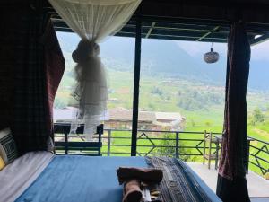 a bedroom with a bed and a window with a view at Sapa Plum Eco House in Sa Pa