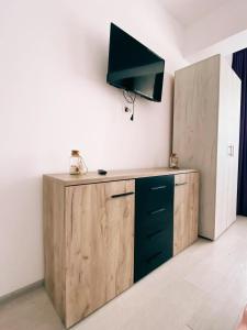 Cette chambre dispose d'un bureau en bois et d'une télévision murale. dans l'établissement MMA Sunset Vibes Mamaia Nord, à Mamaia Nord – Năvodari
