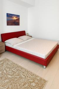 un lit avec un cadre rouge dans une chambre dans l'établissement MMA Sunset Vibes Mamaia Nord, à Mamaia Nord – Năvodari