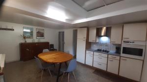 a kitchen with a wooden table and chairs in it at Grande maison Lorraine in Vacqueville