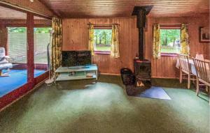 an empty living room with a stove and windows at Gorgeous Home In Ulfborg With Wifi in Ulfborg