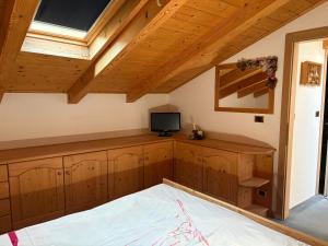 a bedroom with wooden cabinets and a tv on a roof at Casa Defrancesco in Cavalese