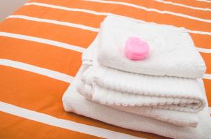 Una toalla blanca con un botón de amor rosa. en Sun Garden l.t., en Fiumicino